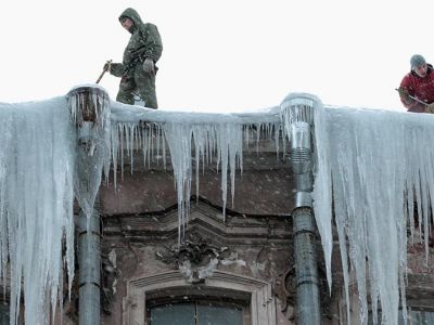 Сотрудники коммунальных служб очищают крыши домов в центре Санкт-Петербурга от сосулек и снежных глыб (архив). Фото: Алексей Даничев / РИА Новости